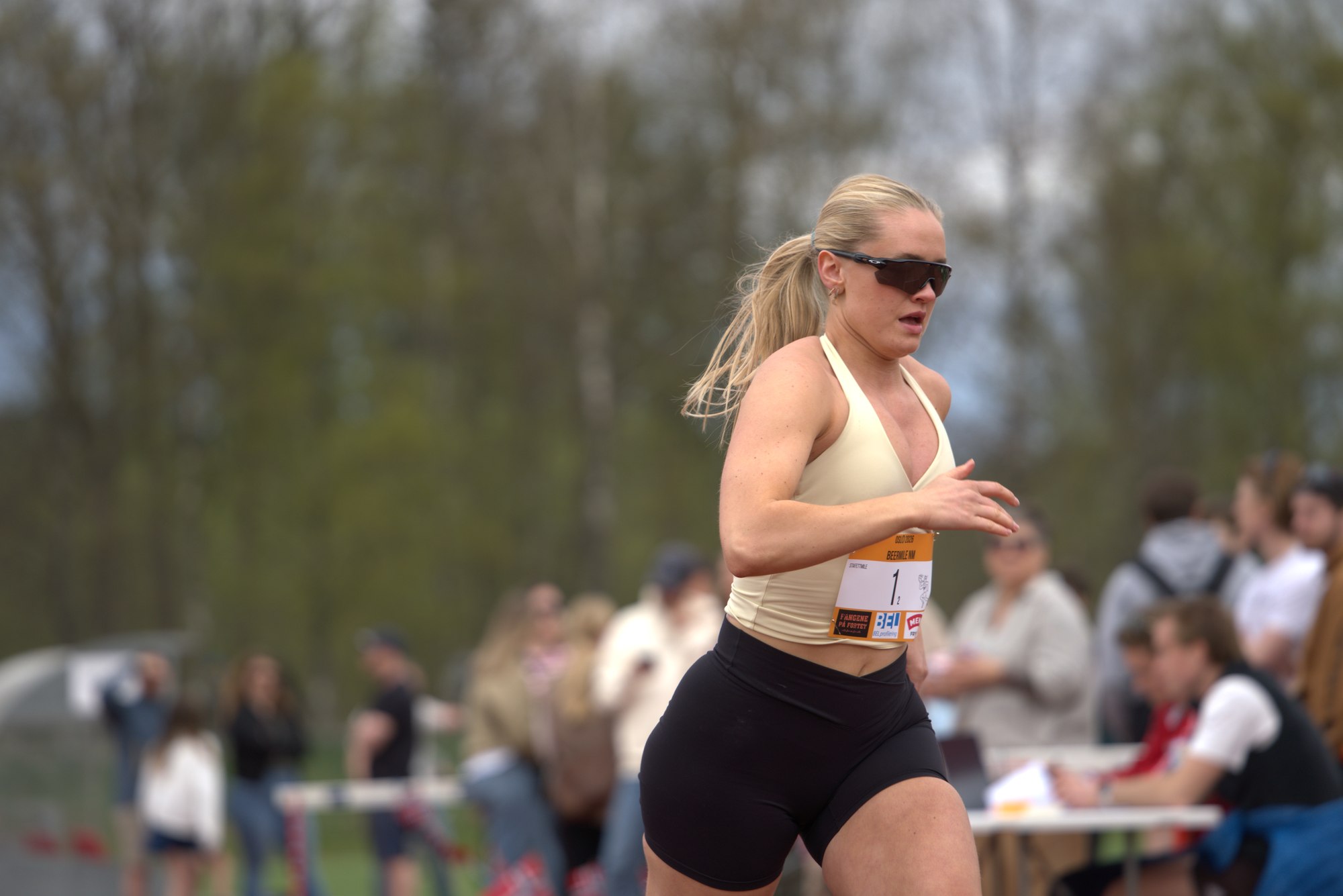 Kvinnelig løper med startnummer 1 løper målrettet på banen