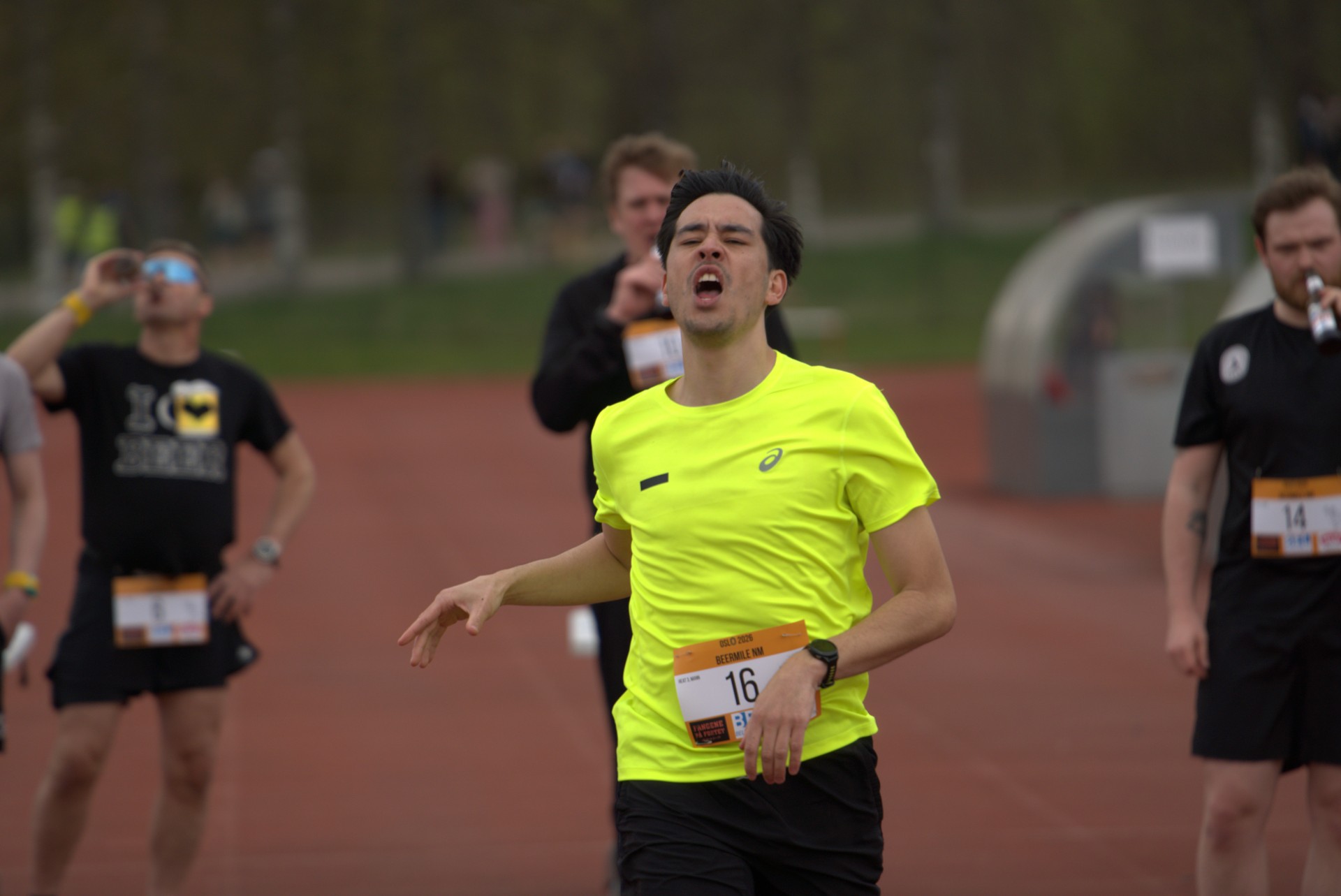 Løper med startnummer 16 i gult skriker med rå følelse i mål